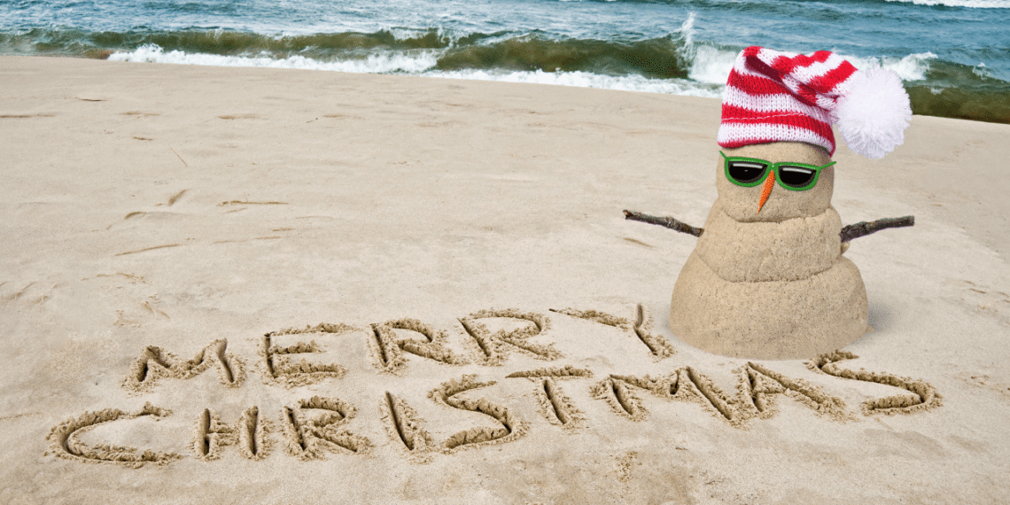 Sand snowman on beach, festive vibe