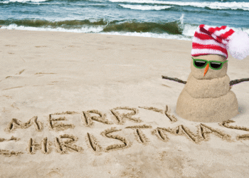 Sand snowman on beach, festive vibe
